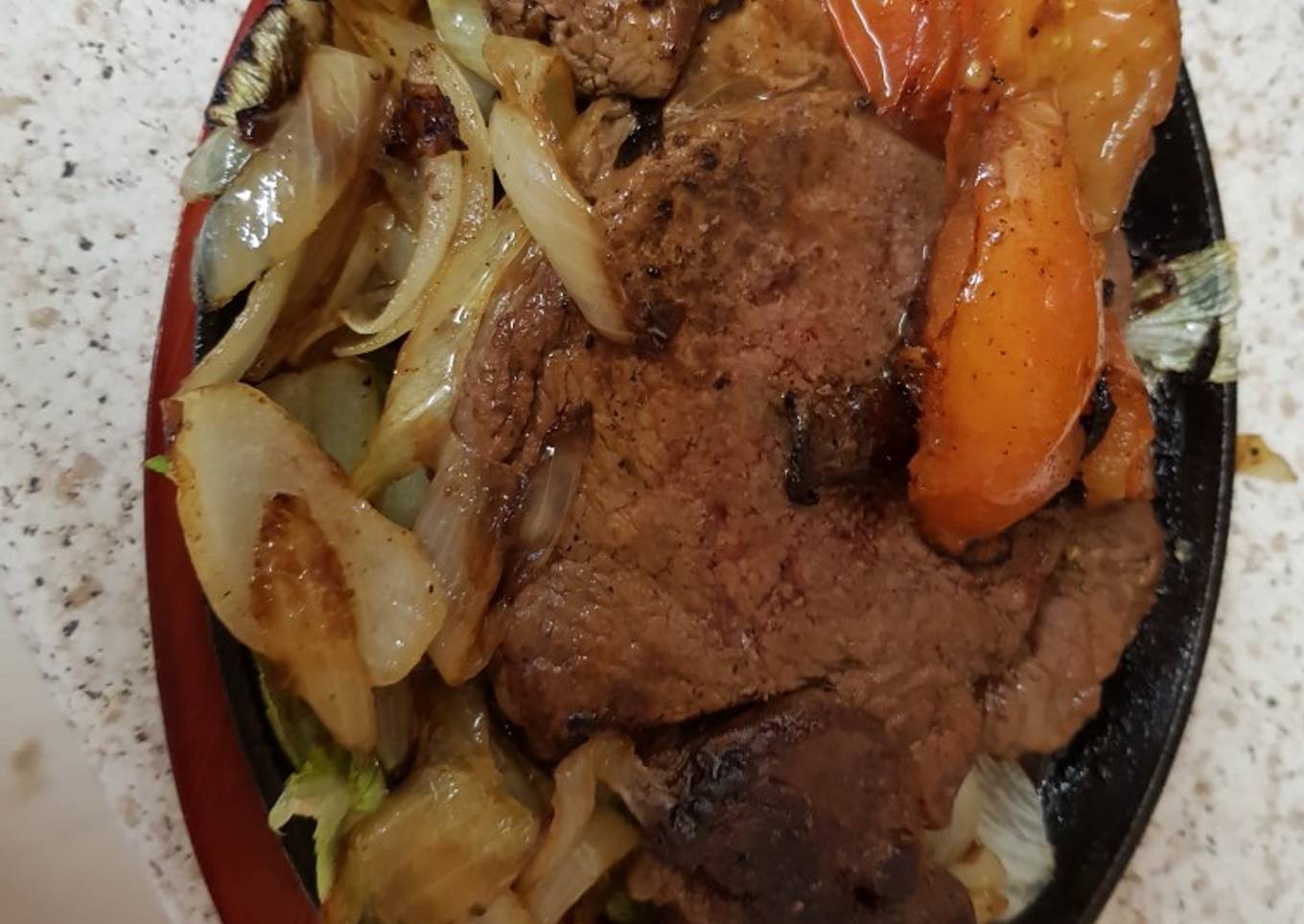 16oz Sizzling Rump Steak on a platter with Mushrooms onions