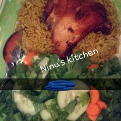 A picture of Jellof rice, fried chicken & simple lemon venaigrette dressing.