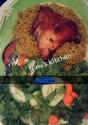 A picture of Jellof rice, fried chicken & simple lemon venaigrette dressing.