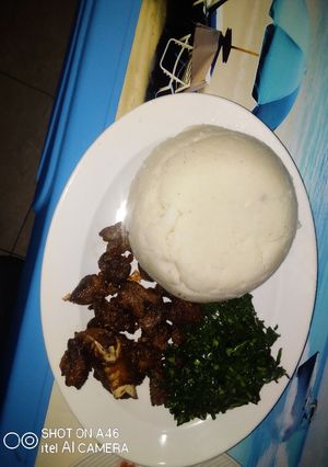 A picture of Pan Fried goat meat served with kales.