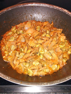 Una foto de Wok de chuletas de aguja con habas y cebolla