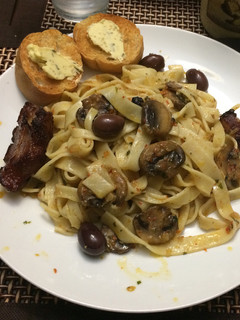 Una foto de Fettuchini y oleo de hongos y calamatas