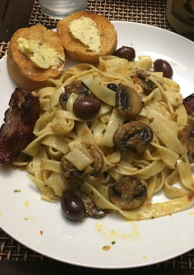 Una foto de Fettuchini y oleo de hongos y calamatas