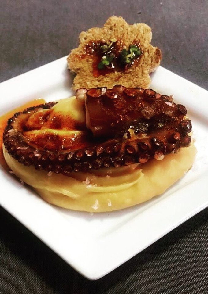 Una foto de Parmentier de boniato con pulpo a la brasa con su tostada de espelta