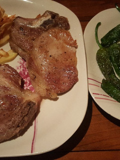 Una foto de Chuletas de cerdo con patatas y pimientos de Padrón