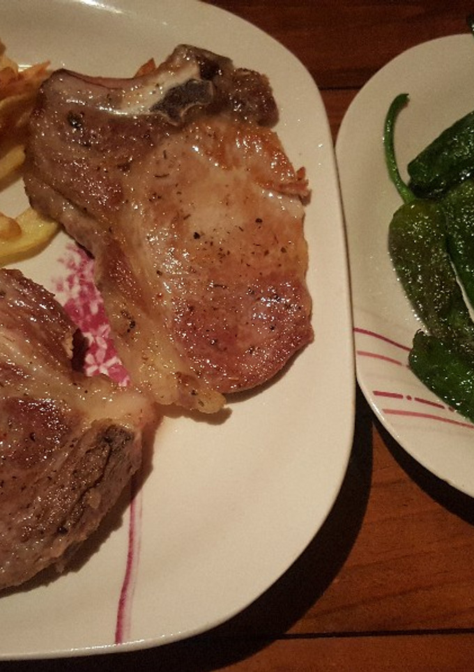 Una foto de Chuletas de cerdo con patatas y pimientos de Padrón