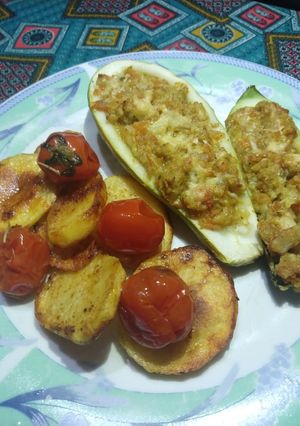 Una foto de Zucchini relleno con papas al horno y tomates confitados