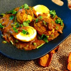 A picture of Boiled egg curry with peas.