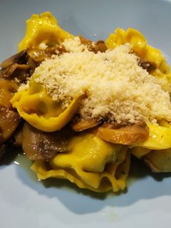 Una foto de Tortellini rellenos de ricotta y espinacas con champiñones