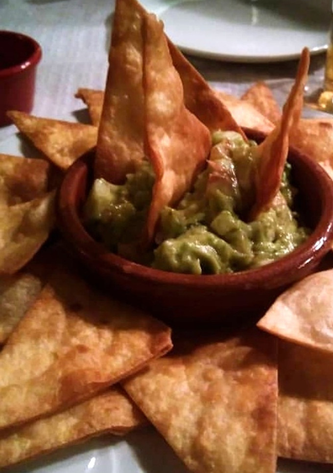 Una foto de Totopos con guacamole y pico de gallo
