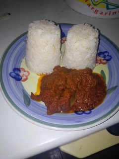 A picture of Twin rice in kpomo and beef sauce.