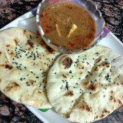 A picture of Paneer masala curry with butter naan.