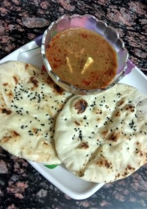A picture of Paneer masala curry with butter naan.