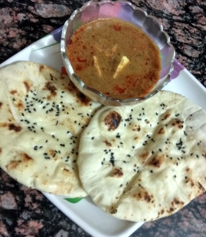 A picture of Paneer masala curry with butter naan.