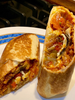 Una foto de Burrito de boloñesa, champis y ensalada de tomate, aguacate y lima