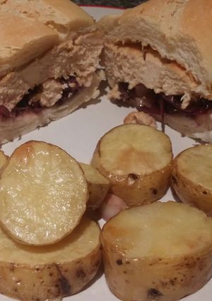 Una foto de Sandwich de pollo con cebollas moradas y papas rústicas