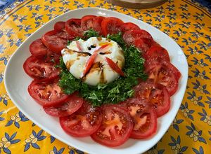 Une photo de Salade composée de tomates et persil à la mozzarella di buffala et crème de balsamique