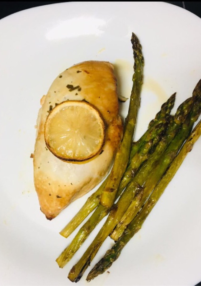 Una foto de Pechuga de pollo al horno con salsa de limón y miel y espárragos trigueros