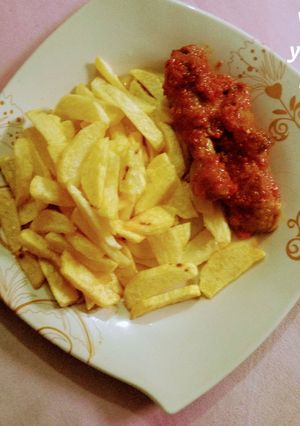 A picture of Fries & sauced chicken.