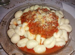 Una foto de Ñoquis de sémola y queso parmesano con salsa bologñesa 