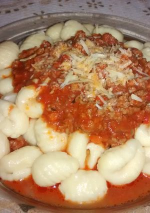 Una foto de Ñoquis de sémola y queso parmesano con salsa bologñesa 