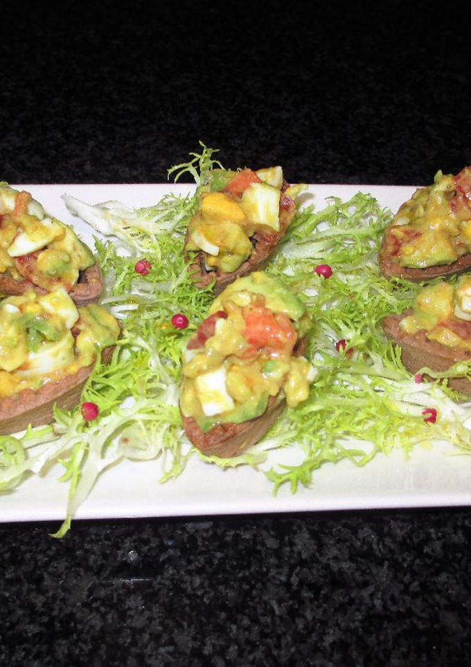 Una foto de Tapas - mini barquitas de cacao rellenas de crudites y huevos sobre escarola