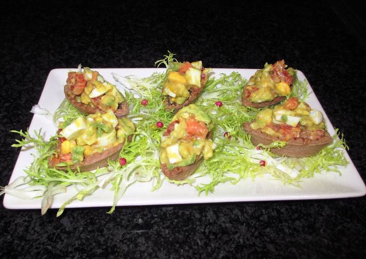 Tapas - mini barquitas de cacao rellenas de crudites y huevos sobre escarola