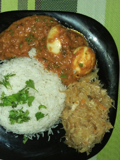 A picture of Rice,Egg Curry and cabbage.