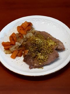Una foto de Carne de potro con pistacho y guarnición