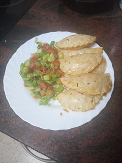 Una foto de Empanadillas de merluza, gambas, palitos de cangrejo y huevo duro al horno con ensalada