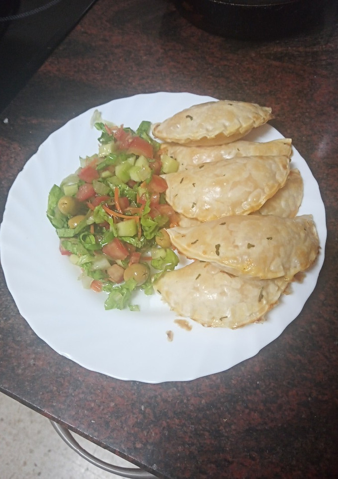 Una foto de Empanadillas de merluza, gambas, palitos de cangrejo y huevo duro al horno con ensalada