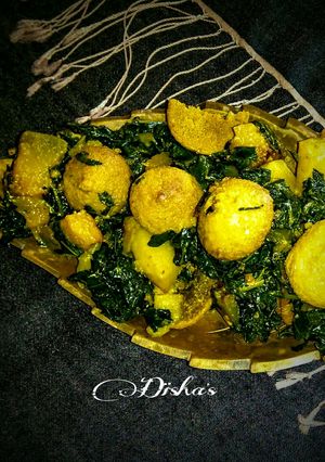 A picture of Jute leaves curry with pumpkin-potato-sundried lentil dumplings.