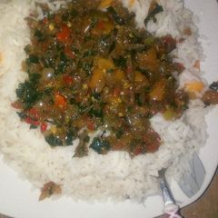 A picture of White rice with ugu soup.