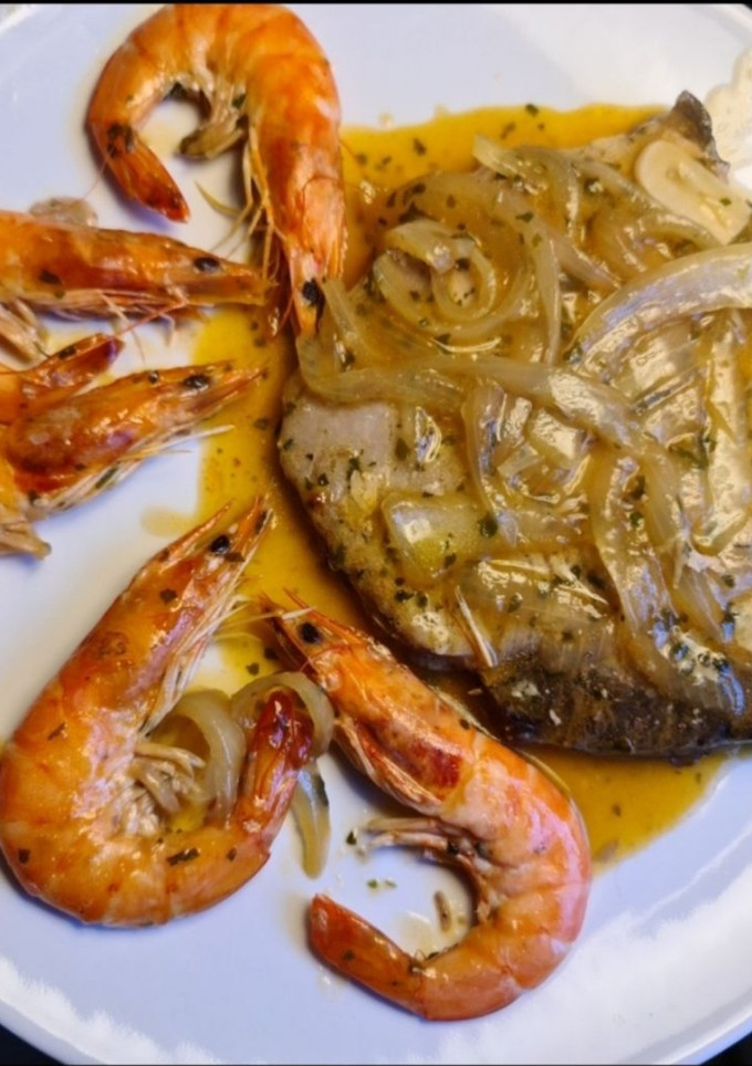 Una foto de Atún encebollado con langostinos