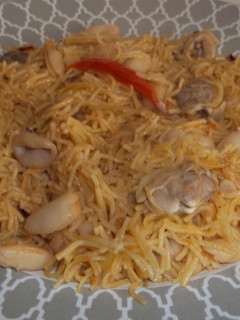 Una foto de Fideos finos con judías blancas, calamares y almejas