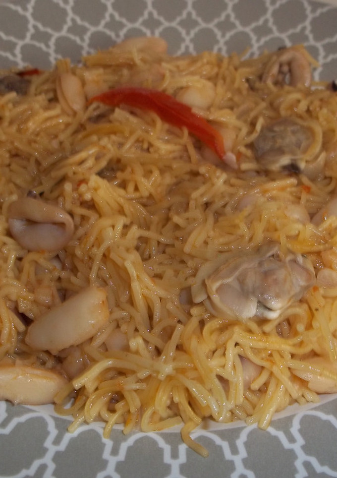Una foto de Fideos finos con judías blancas, calamares y almejas