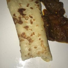 A picture of Pancake with sauced beef.