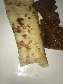 A picture of Pancake with sauced beef.
