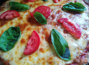 Una foto de Pizza de masa integral con tomate y albahaca 🍕🌱🍅
