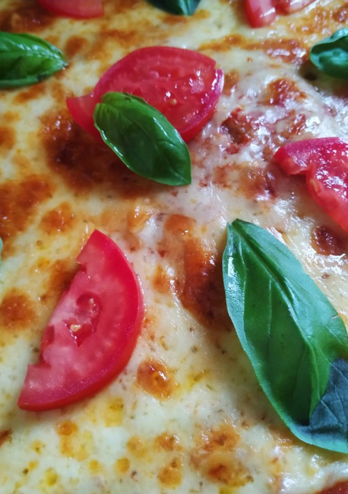 Una foto de Pizza de masa integral con tomate y albahaca 🍕🌱🍅