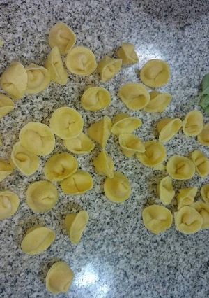 Una foto de Capelletti de calabaza sobre salsa concasse