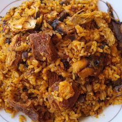 A picture of Palmoil rice with smoked fish and bacilia leaf.