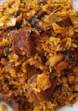 A picture of Palmoil rice with smoked fish and bacilia leaf.