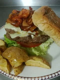 Una foto de Hamburguesa de mar y tierra con casquitos de papa