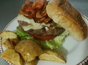 Una foto de Hamburguesa de mar y tierra con casquitos de papa