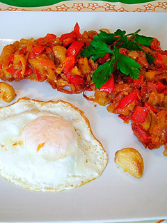 Una foto de Huevo frito con pimiento rojo, berenjena y cebolla morada