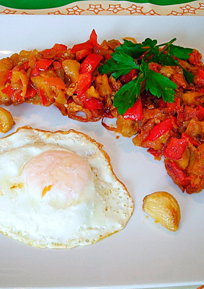 Una foto de Huevo frito con pimiento rojo, berenjena y cebolla morada