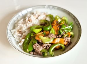 Une photo de Bœuf sauté aux poivrons, servi avec du riz blanc