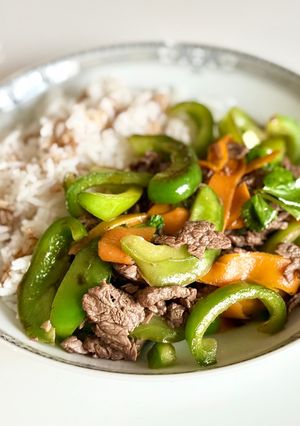 Une photo de Bœuf sauté aux poivrons, servi avec du riz blanc