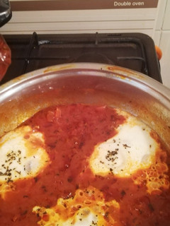 A picture of Shakshouka (eggs in tomato and basil sauce).
